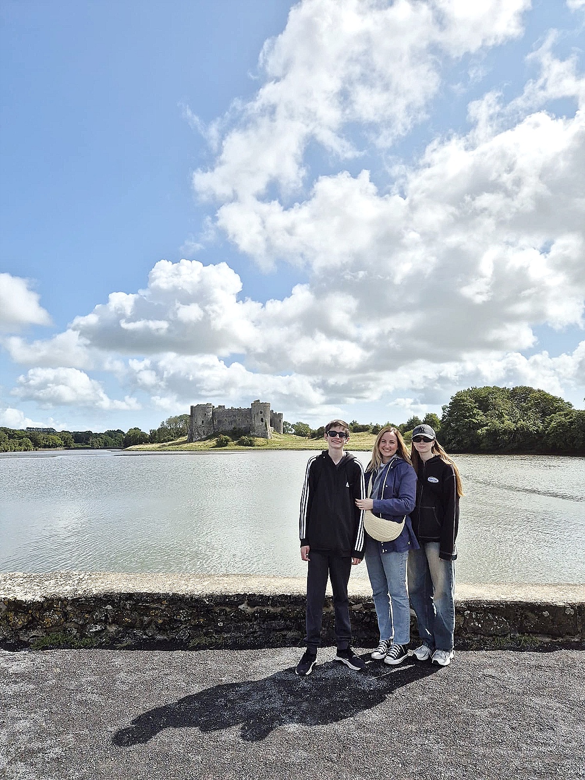 franky and her two teenage children posing beside a castle in wales