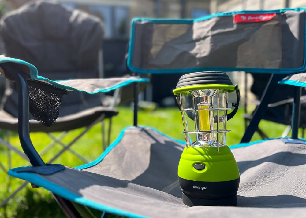 Green camping lantern placed on a camping chair