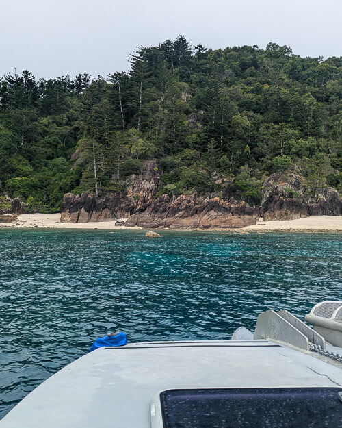 View of a beach in the Whitsunday Islands from a boat just off the shore