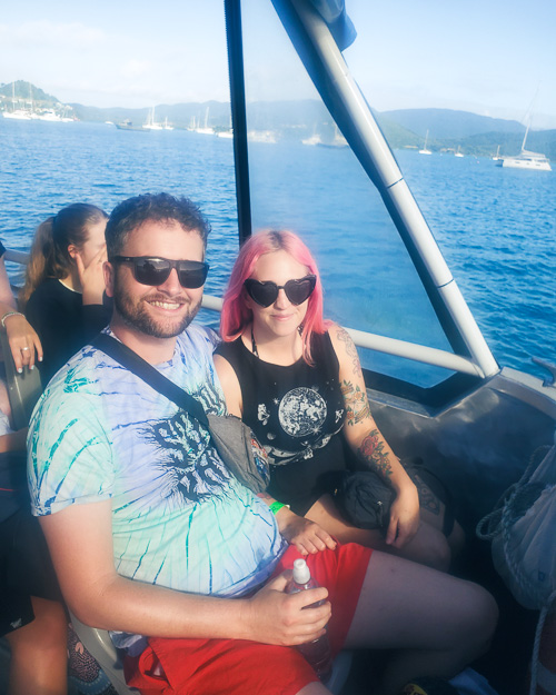 Ashley and Milly are sat in the front of a boat at the Whitsunday Islands